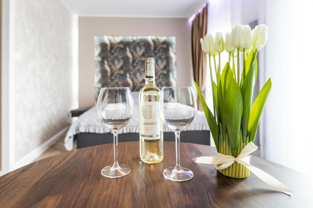 una botella de vino y dos copas de vino en una mesa en GDAŃSK nad MOTŁAWĄ nowy Apartament Nadmotławie, en Gdansk