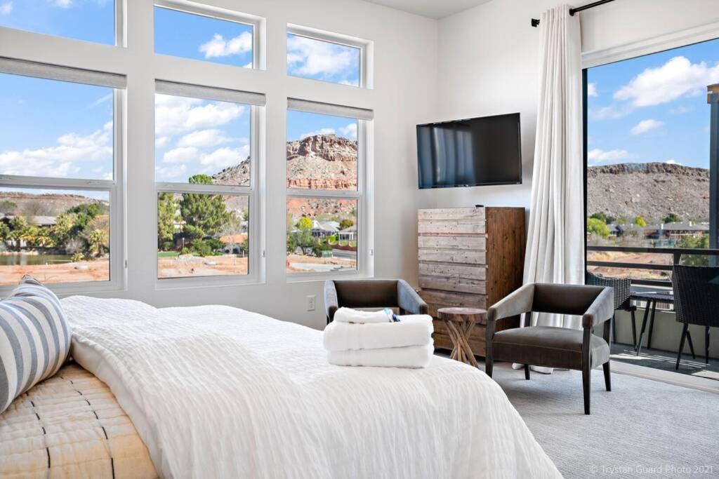 a bedroom with a large white bed and windows at Villa #24 at Bloomington Country Club in St. George