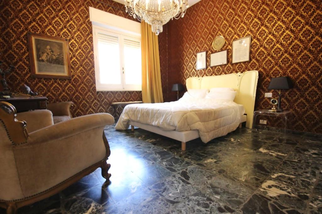 una camera con letto, sedia e lampadario a braccio di Il Chiostro a Cagliari