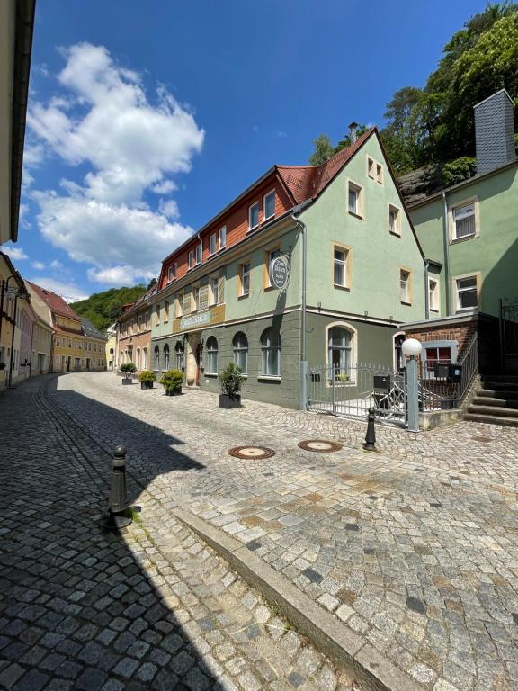 a cobblestone street in a town with buildings at Hotel Garni „zum Bären“ in Bad Schandau