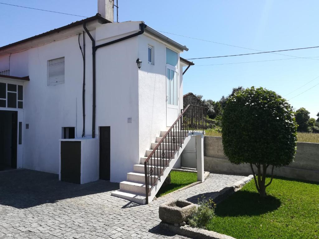 un edificio blanco con una escalera en un patio en Santo Tirso Holidays Home, en Santo Tirso