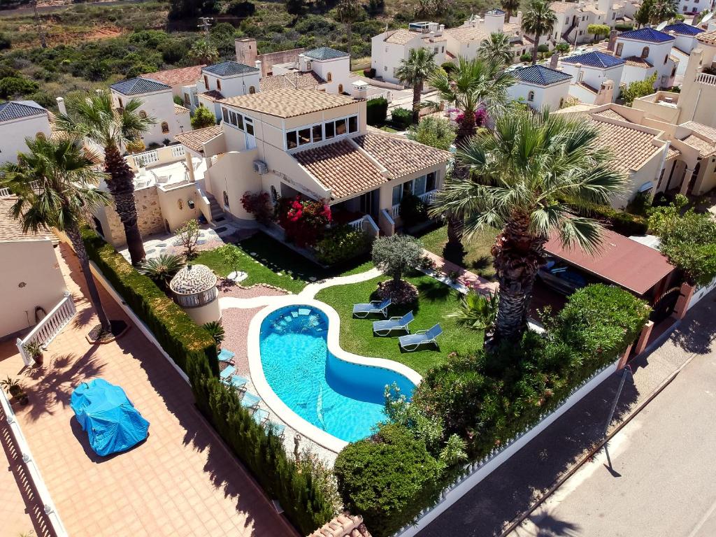 an aerial view of a house with a swimming pool and palm trees at Holiday VILLA GOLF & SEE VIEW Villamartin in Orihuela Costa