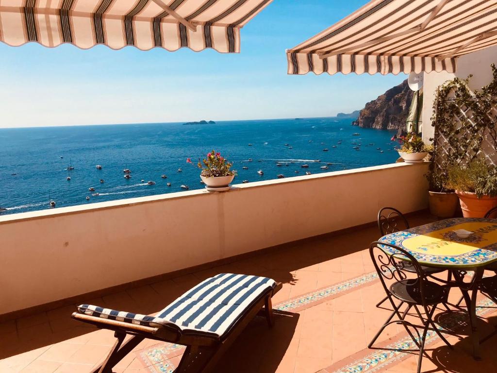Un balcón con sillas y vistas al océano. en Casa Marty en Positano