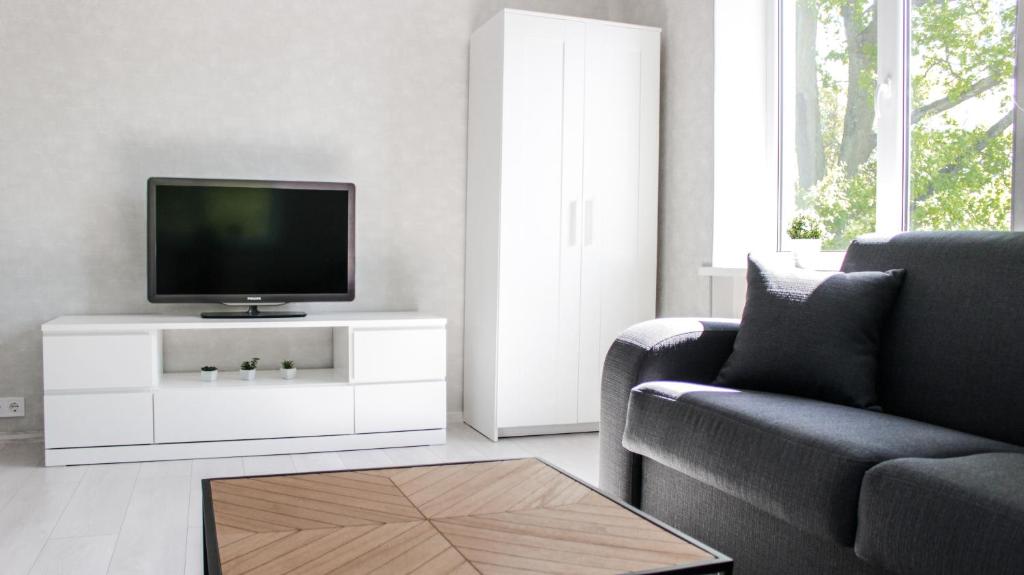 a living room with a tv on a white cabinet at Centrum Apartement in Valga