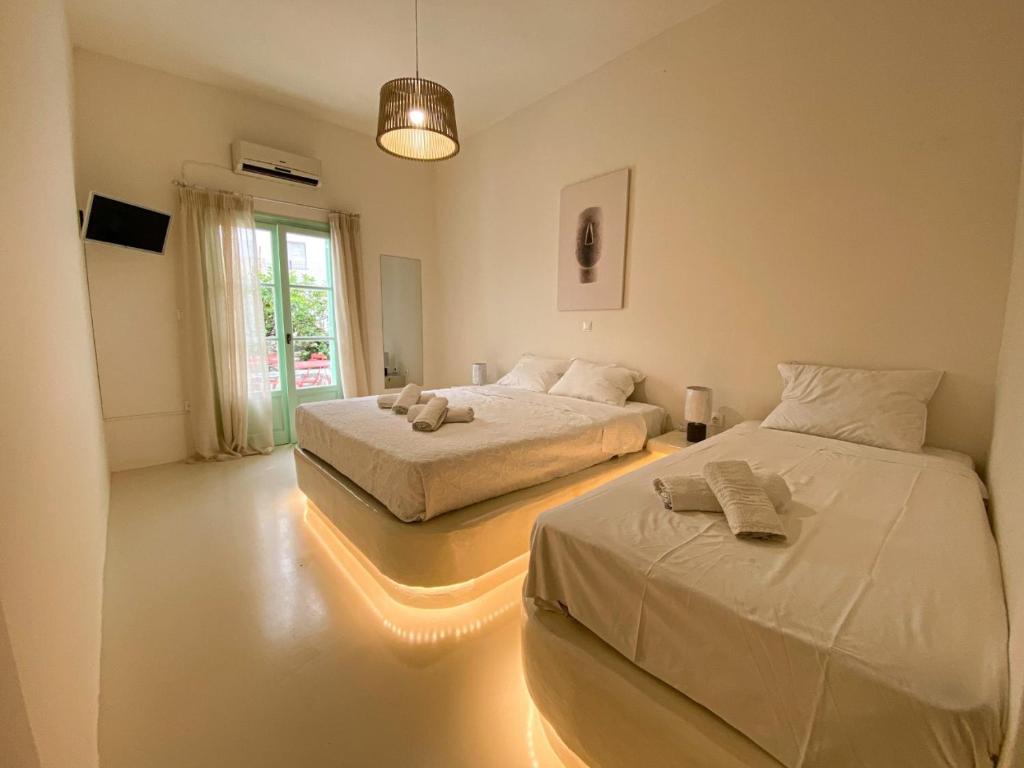 two beds in a room with lights on the floor at Orion in Naousa