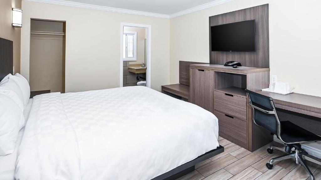 a hotel room with a bed and a desk and a computer at Sea Rock Inn - Long Beach in Long Beach