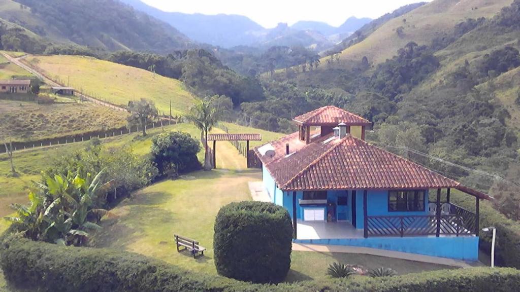 una pequeña casa en un campo con una montaña en Casa em São Francisco Xavier/sp, en São Francisco Xavier