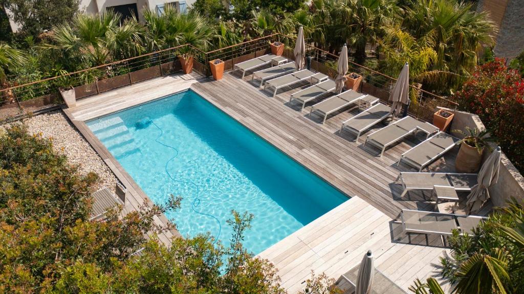 a swimming pool with chaise lounge chairs and a swimming pool at Suites in Erbalunga in Erbalunga