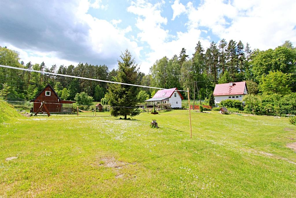 a field with houses and a fence and a field with a fire hydrant at Domki wczasowe Mazury - Ferienhaus Masuren - do 12 osób - idealny dla grup in Dłużek