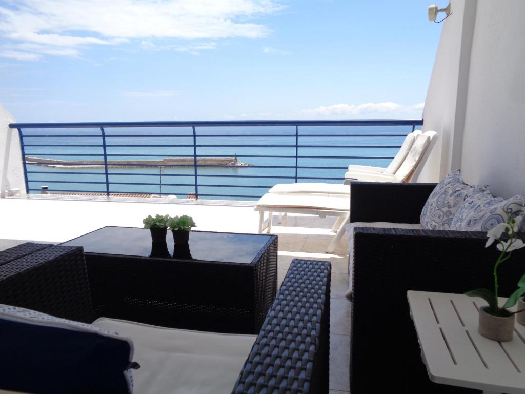 Un balcón con sillas y mesas y vistas al océano. en Ada Calypso Apartamento, frente al mar y castillo, Parking, Aire acondicionado, WiFi, Piscina, en Peñíscola