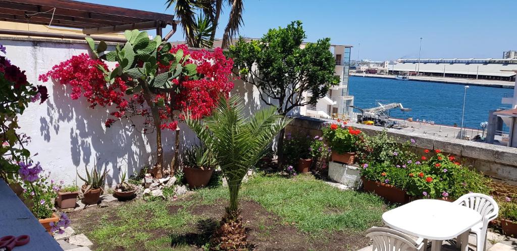 a garden with flowers and plants next to the water at La Casa Sul Porto in Brindisi