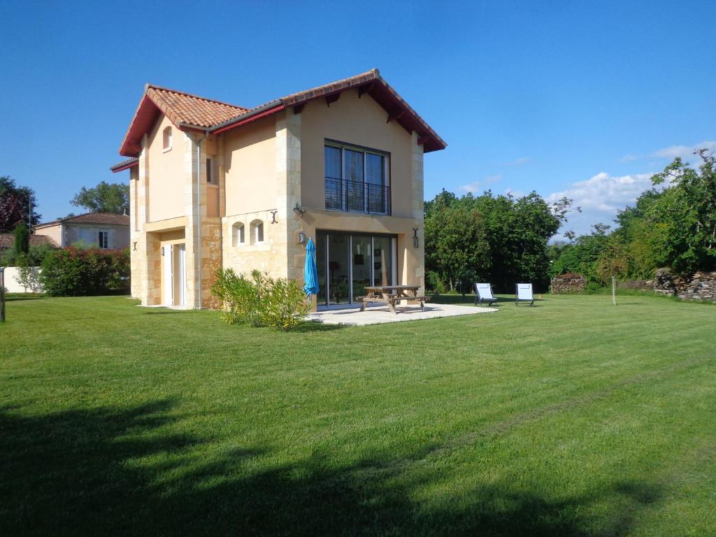 a house with a grassy yard in front of it at GRANGE LA BIGARDERIE in Blaye