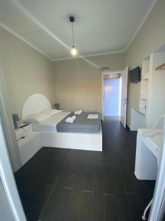 a bedroom with a large bed and a hallway at AEGEAN VIEW SEASIDE ROOMS AND STUDIOS KEA in Korissia