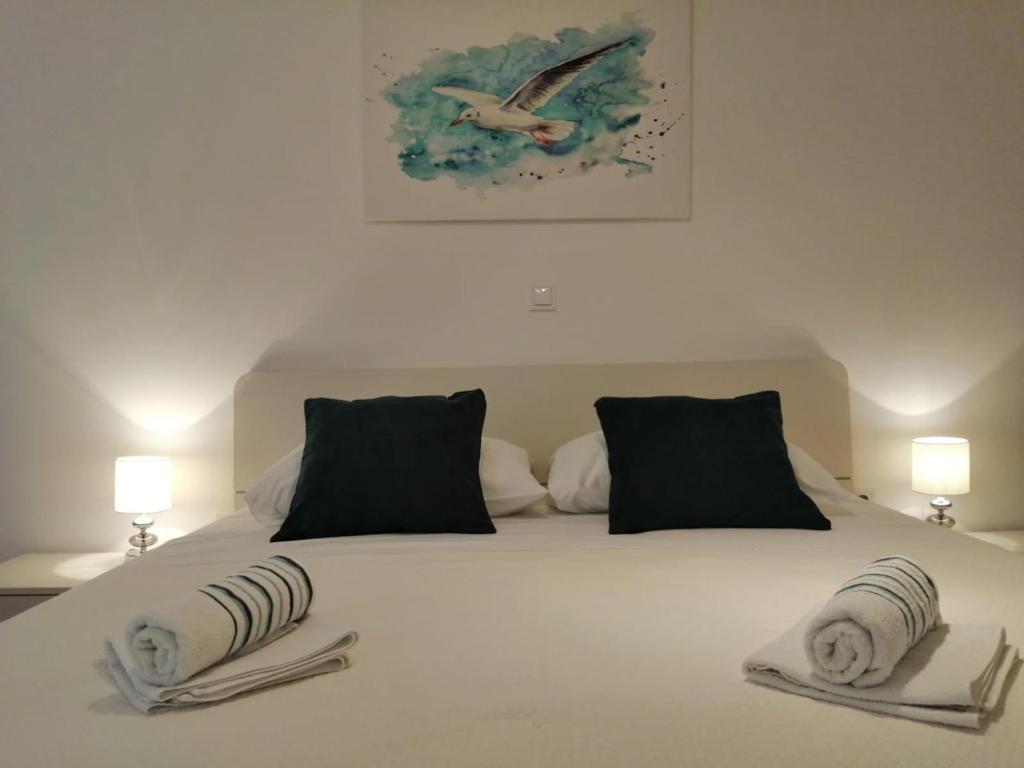 1 dormitorio con 1 cama blanca y 2 almohadas en Room Mina, en Rovinj