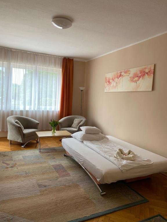a bedroom with two beds and a living room at CentROOM Nagykanizsa in Nagykanizsa