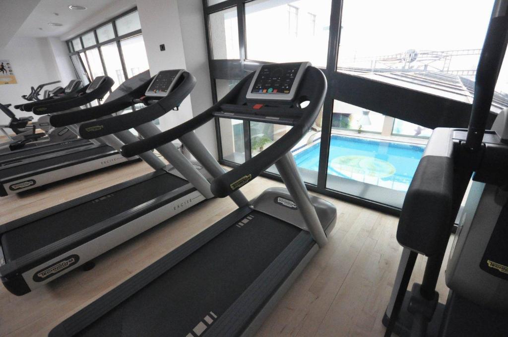 a gym with several treadmills and a swimming pool at Hotel EMD in Bacău