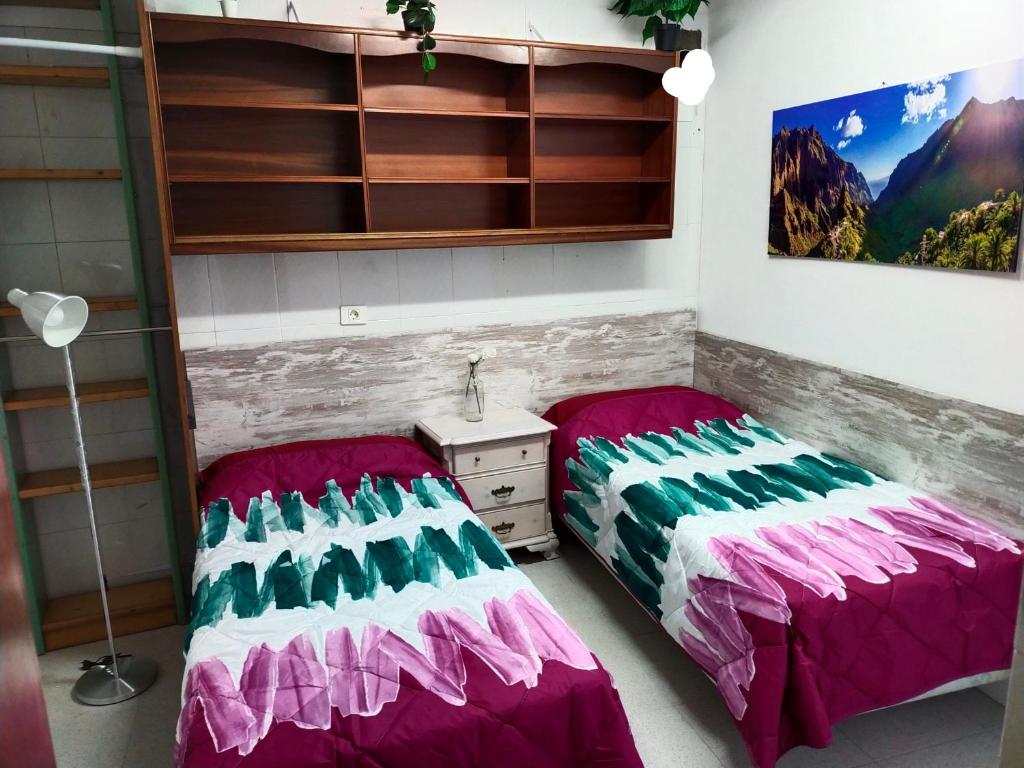 a room with two beds and a dresser in it at va de Loft in La Laguna