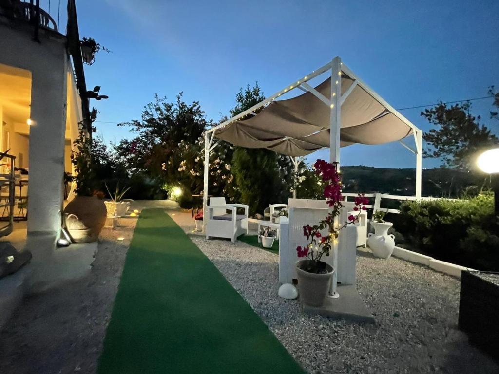 een huwelijksceremonie onder een witte tent met een groen gazon bij Villa Rosa in Agropoli