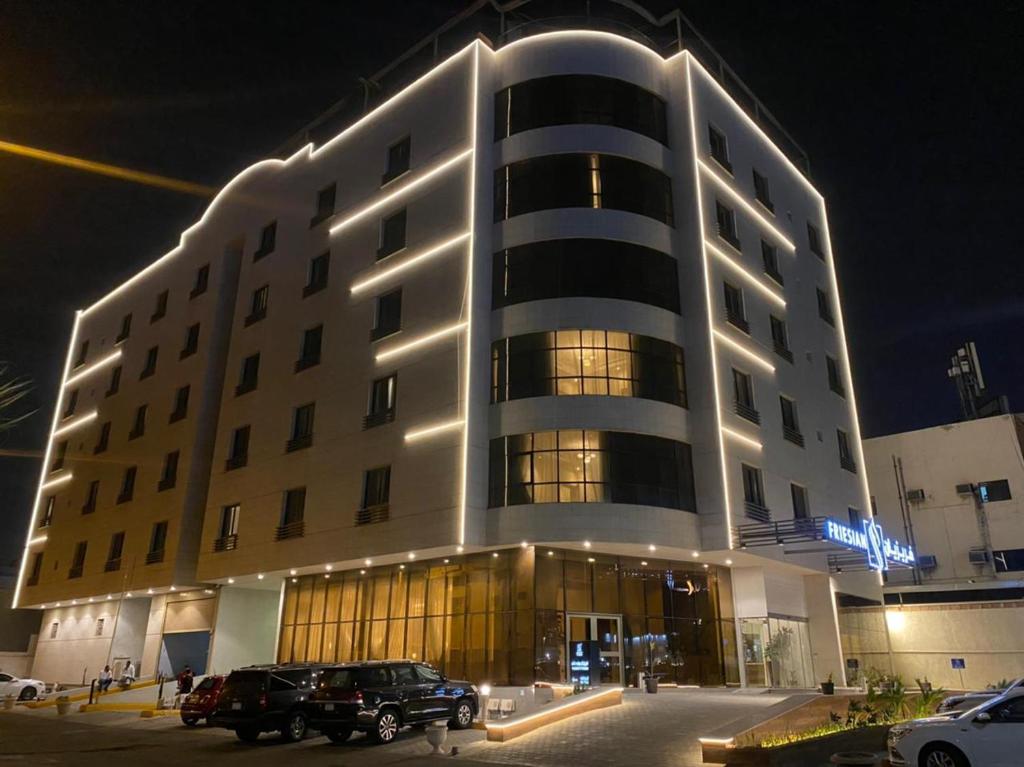 un gran edificio con coches estacionados frente a él en Friesian Hotel Suites, en Yeda