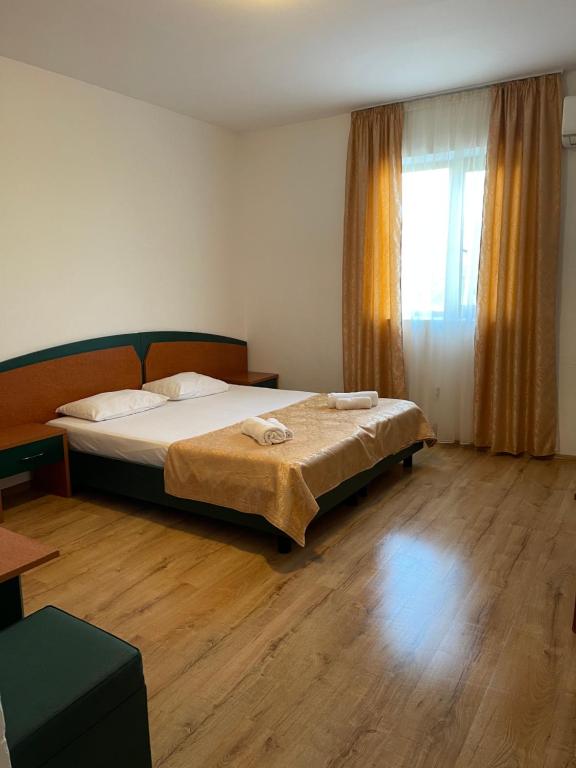 a bedroom with a bed and a large window at Hotel Oltenia in Eforie Sud