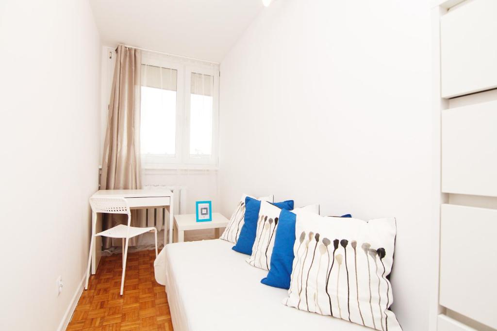 a white bedroom with blue and white pillows on a bed at Blue River - Jelenia in Wrocław