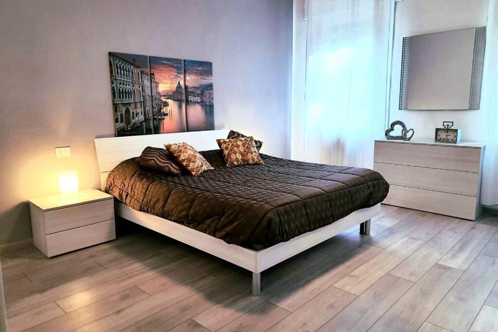 a bedroom with a large bed with two nightstands and avertisement at Marco's apartment -ideale per Venezia- in Mestre