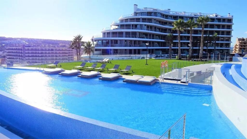 a large swimming pool next to a large building at INFINITY VIEW Arenales in Arenales del Sol