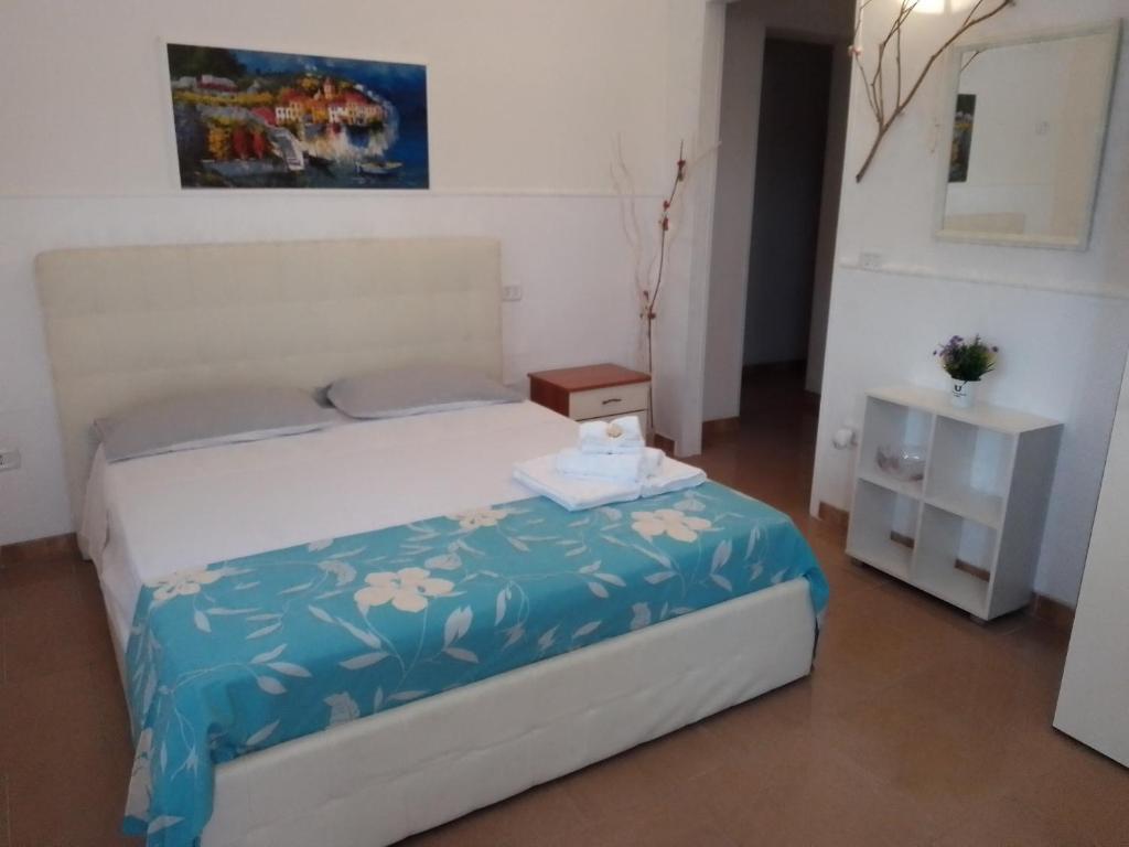 a small bedroom with a bed and a night stand at Camera Noemi in Torre Lapillo