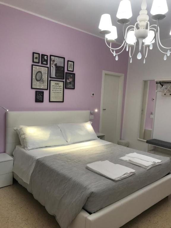 a bedroom with a large bed and a chandelier at Residenza Aurea in Offida