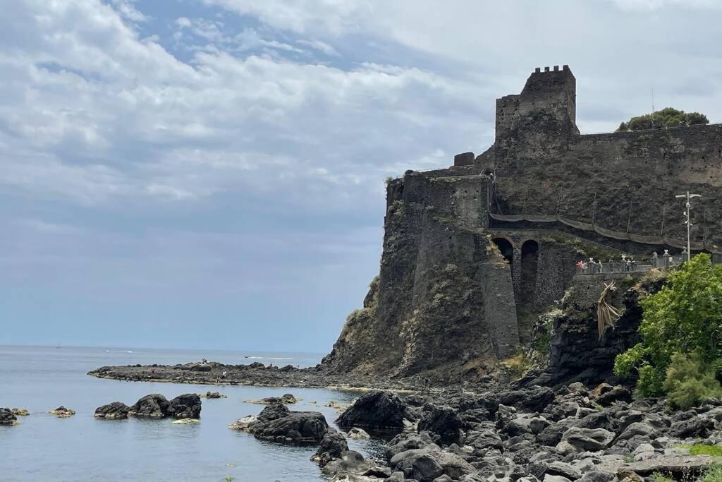 a castle on the shore of a body of water at donna serena Aci Castello in Aci Castello