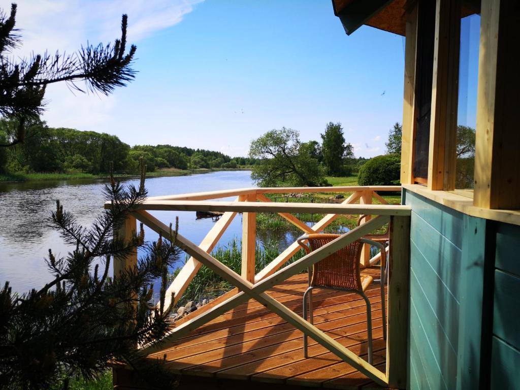 a wooden deck with a view of a river at Kaptenimaja koos saunaga in Tartu