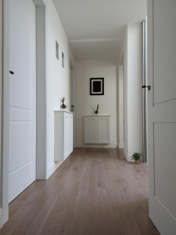 um corredor vazio com paredes brancas e piso de madeira em Castle Rooms em Prato