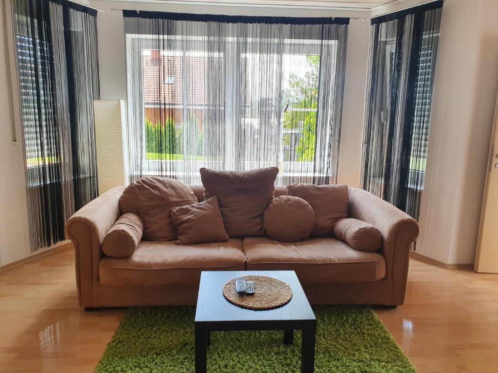 sala de estar con sofá marrón y mesa en Apartment/Ferienwohnung im ruhigen Calden in der nähe von Kassel, en Calden