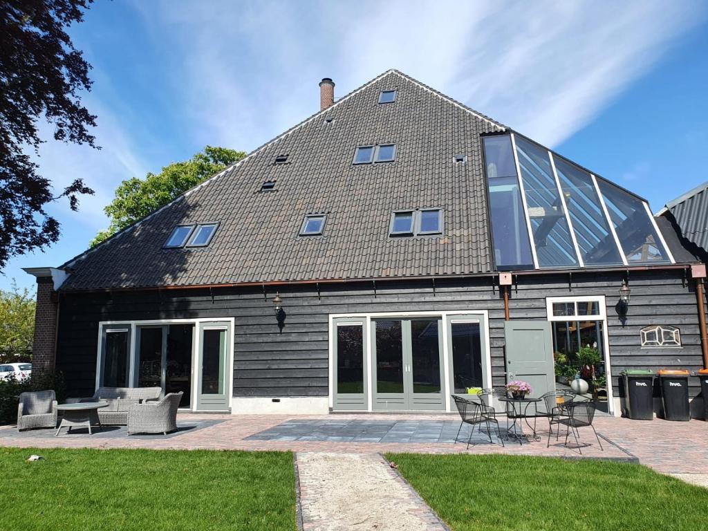 a house with a solarium on the side of it at Bed & Breakfast De Leekerhoek in Oosterleek