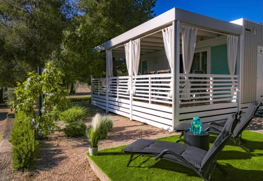 a white gazebo with a chair and a table at M&L Mobile Home in Jezera