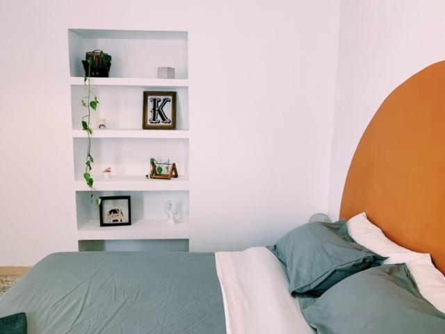 1 dormitorio con 1 cama y estanterías en la pared en Maria Magdalena - Room 3, en Málaga