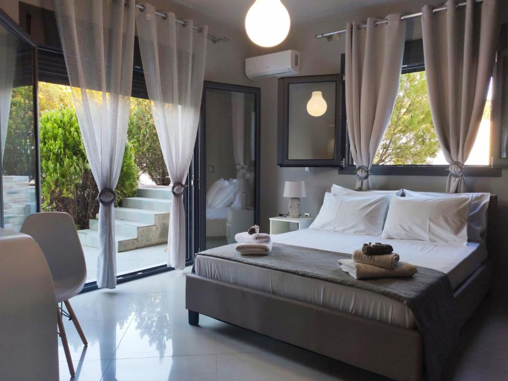 a bedroom with a bed with towels on it at Villa Rose Ground Floor - Private Swimming Pool Garden in Koskinou