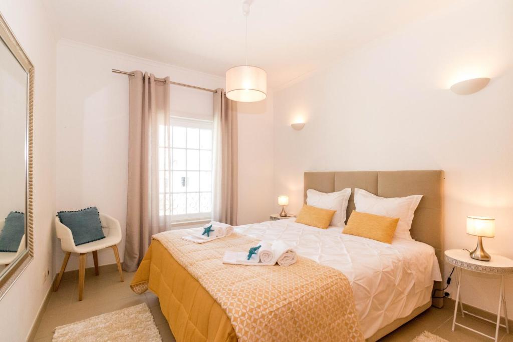 een slaapkamer met een bed met twee handdoeken erop bij ALzira By Rossio in Albufeira