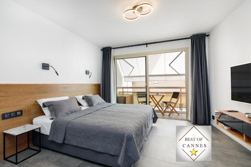 a bedroom with a bed and a tv and a balcony at Cannes CROISETTE, Palais des Festivals, Beaches, Apart Residence Le MINERVE in Cannes