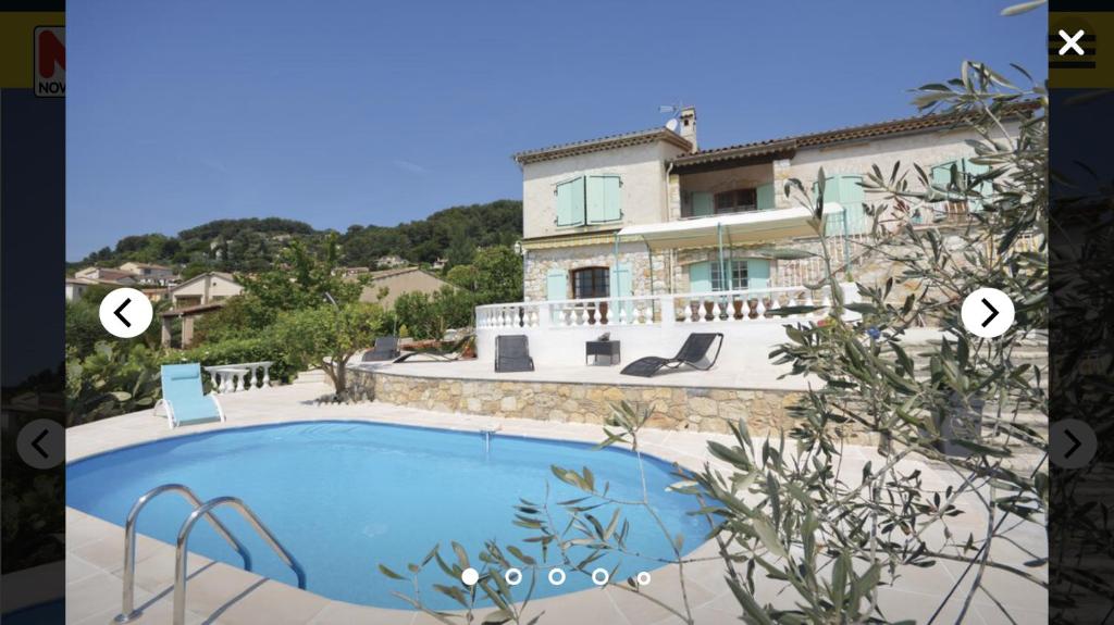 une maison avec une piscine en face d'une maison dans l'établissement Villa des 11 colombes, à La Colle-sur-Loup