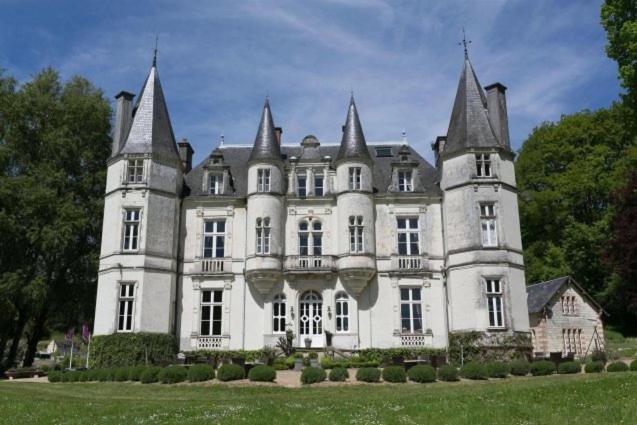 un gran castillo blanco con cuatro torres en un campo en Château de Vallagon, en Bourré