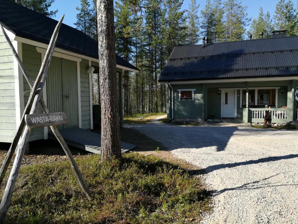 une maison avec un panneau devant elle dans l'établissement Villa Wästä-Räkki, à Luosto