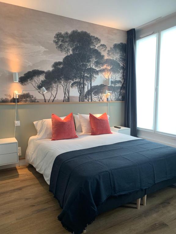 - une chambre avec un grand lit et des oreillers rouges dans l'établissement TY STUDIOS Hyper Centre Ville, à Brest