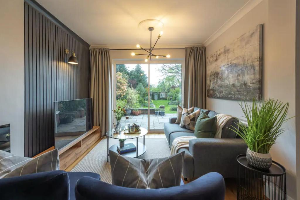ein Wohnzimmer mit Sofas und einem großen Fenster in der Unterkunft Large Luxury 5 Bedroom Solihull House, Sleeps 9 - Close to NEC, Birmingham BHX Airport in Solihull