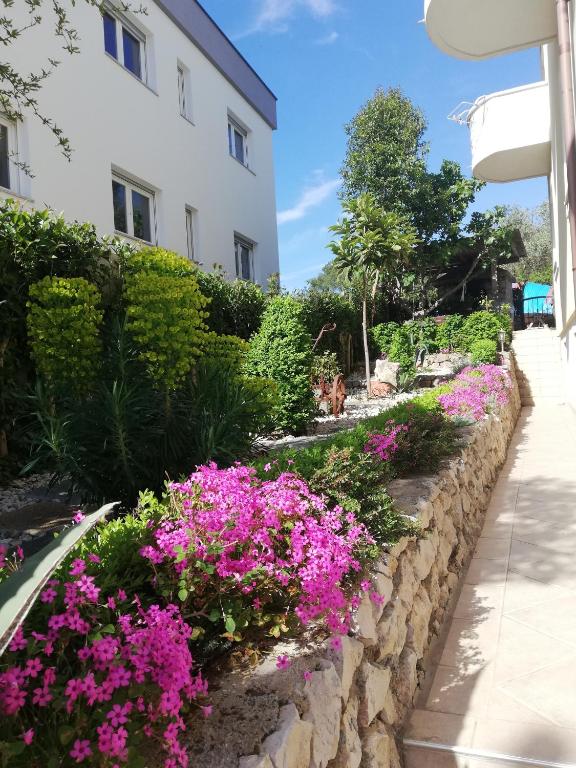 a retaining wall with flowers in front of a building at Villa Maslina in Zadar