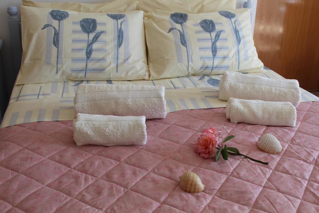 un letto con 2 cuscini e una trapunta rosa di Vakis Apartments 2 a Romanón