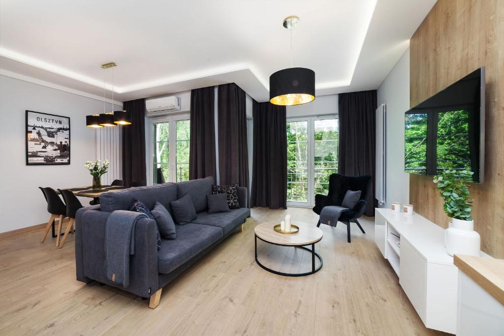 a living room with a blue couch and a table at Villa Jana in Olsztyn