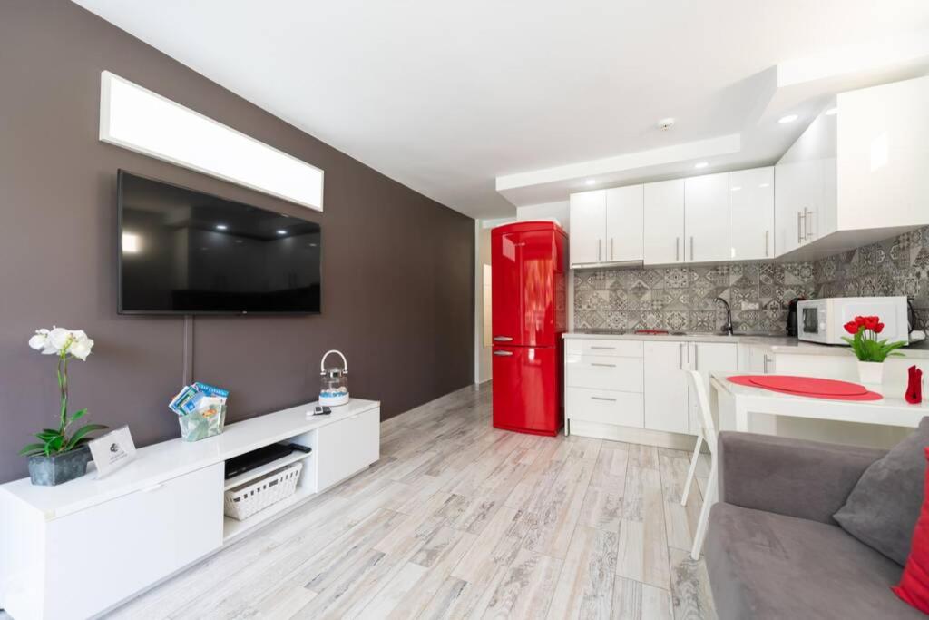 a kitchen with a red refrigerator and white cabinets at Luxury apt 1 MINUTE from the Beach of the Dunes in Playa del Ingles