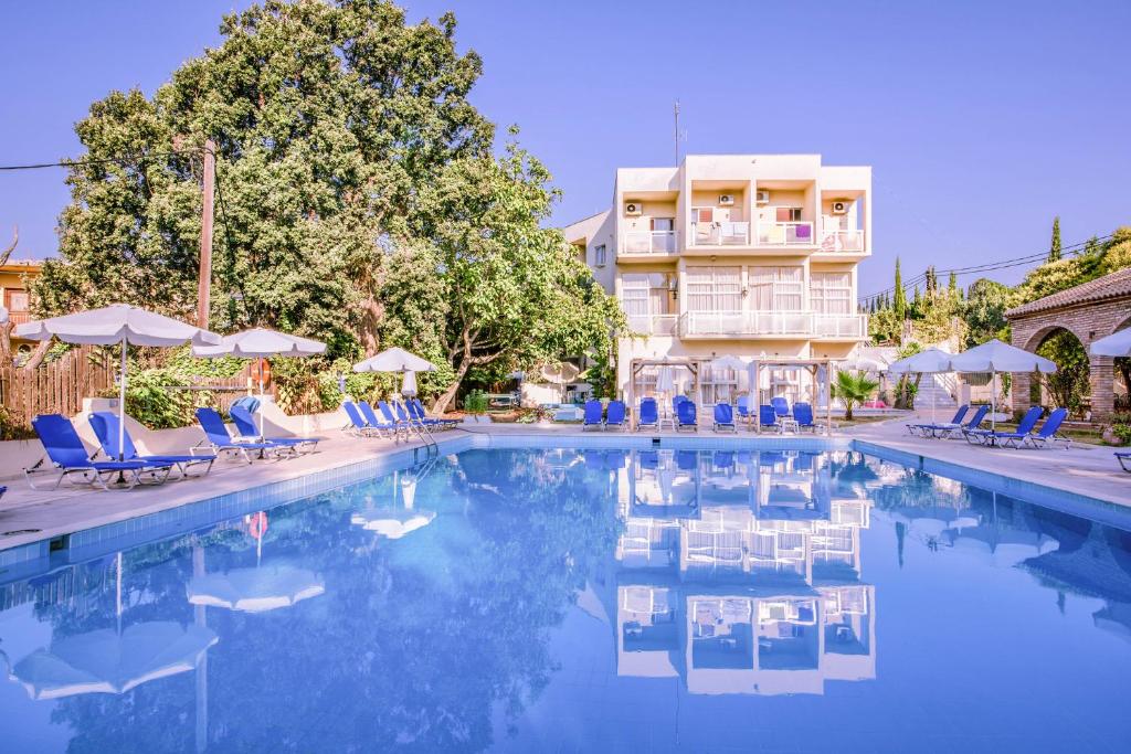 een zwembad met blauwe stoelen en een gebouw bij Amalia Corfu Hotel in Corfu-stad