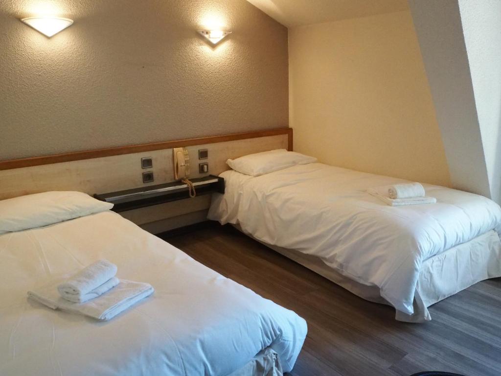 Rúm í herbergi á HOTEL LE FOIRAIL
